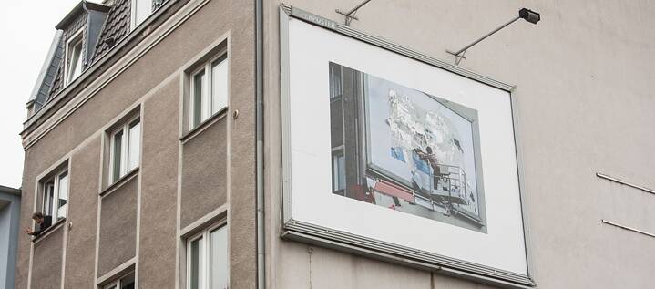 Für das CityLeaks Festival 2019 buchte der Künstler Andrey Ustinov eine Plakatfläche in Köln-Ehrenfeld und beklebte sie mit einem Foto von sich selbst als Plakatkleber. „Iconoclach“ blieb 20 Tage bestehen, danach endete die Mietzeit für die Plakatfläche.