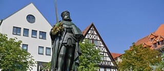 Die „Hanfried“-Statue auf dem Jenaer Marktplatz: Frischgebackenen Doktor*innen dient er als Wurfziel für ihre Buchsbaumkränze. 