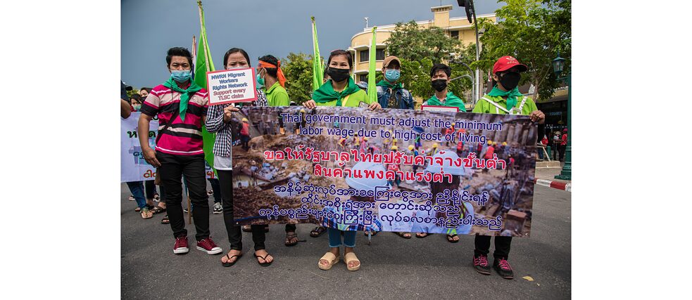 Le 1er mai 2022 à Bangkok, en Thaïlande : lors d’une manifestation, des travailleurs et travailleuses migrant·e·s déploient une banderole sur laquelle on peut lire leur opinion. 