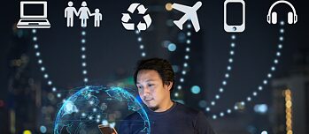 Man met mobiele telefoon voor een hologram van een wereldbol met op de achtergrond verschillende symbolen zoals een vliegtuig of een computer.