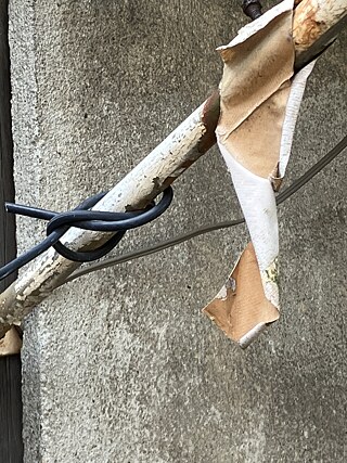 Close-up, a rod wrapped by pieces of cable, with a scrap of awning fabric