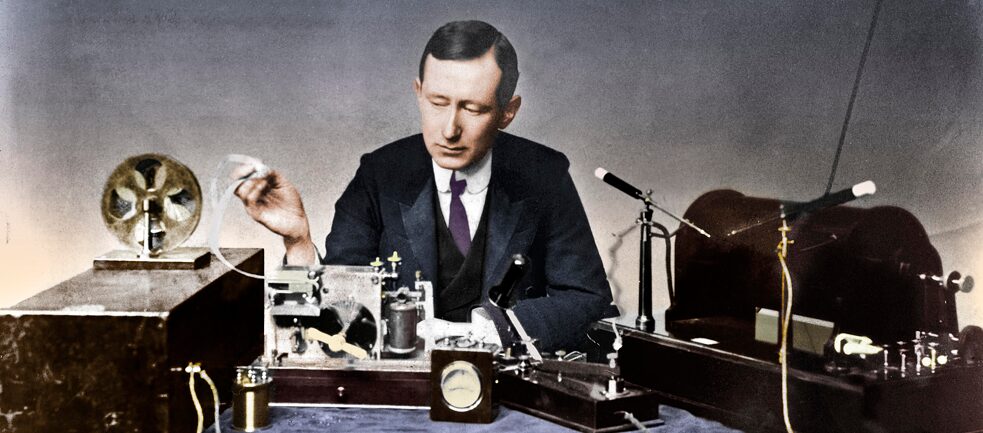 L'ingénieur italien Guglielmo Marconi tente en 1902 une première transmission radio transatlantique  – en code Morse ! Marconi, avec un émetteur radio et un manipulateur Morse (photographie non datée). 