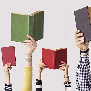 Mehrere Hände halten Bücher in die Luft