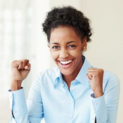 A young woman clenching her fists in joy.