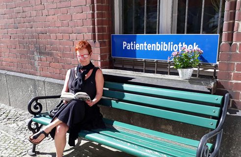 Ein beliebter Leseplatz bei schönem Wetter: die Bank vor der Patientenbibliothek