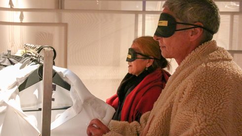 Zwei Besucherinnen mit Augenmaske ertasten die Exponate
