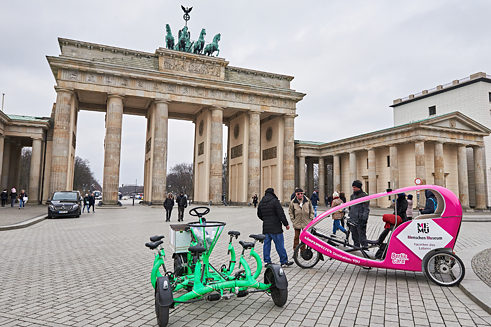 Skupinové kolo a velotaxi stojí před Braniborskou bránou v Berlíně.