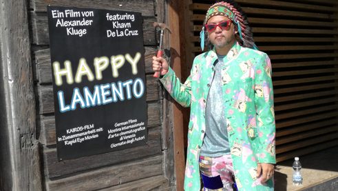 Khavn de la Cruz vor dem Poster des Films „Happy Lamento“