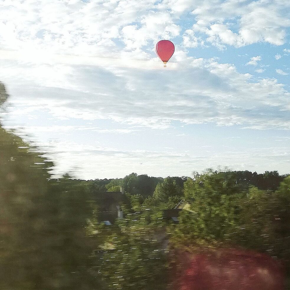 Zicht uit het venster van de RER-trein op het voorbijglijdende landschap