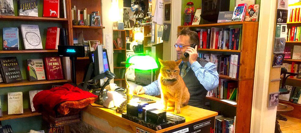 Le véritable patron de la librairie culte Bücher’s Best à Dresde n’est autre qu’un chat : Myamoto Musashi, le matou de la boutique, avec Jörg Stübling, surnommé « Stü ».