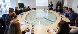 Participants of the EU-Kurs Frankfurt-Wiesbaden 2017 sit around a table in a lecture with a model of the city of Frankfurt in the middle