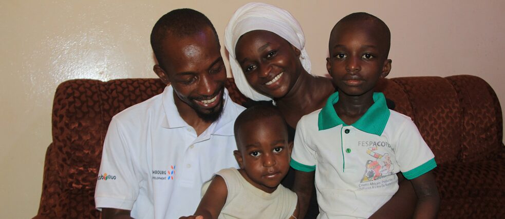 La famille Bonkoungou assise ensemble sur le canapé.