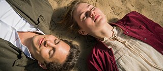 Hello Again - A Wedding a Day, film still: a woman and man lying on a sandy surface