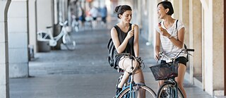 Zwei Frauen auf Rädern essen Eis