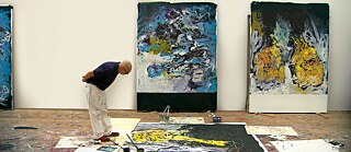 Der Künstler, gebeugt über eines seiner Gemälde
