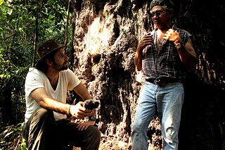 Felipe Milanez interviews José Claudio Ribeiro da Silva next to a Brazil nut tree called Majestade (Majesty), inside the agroextractivist settlement project Praialta Piranheira, city of Nova Ipixuna, in the state of Pará. Brazil, 2010. José Cláudio and his wife Maria, a couple of environmental defenders, were killed on 24th May 2011. 