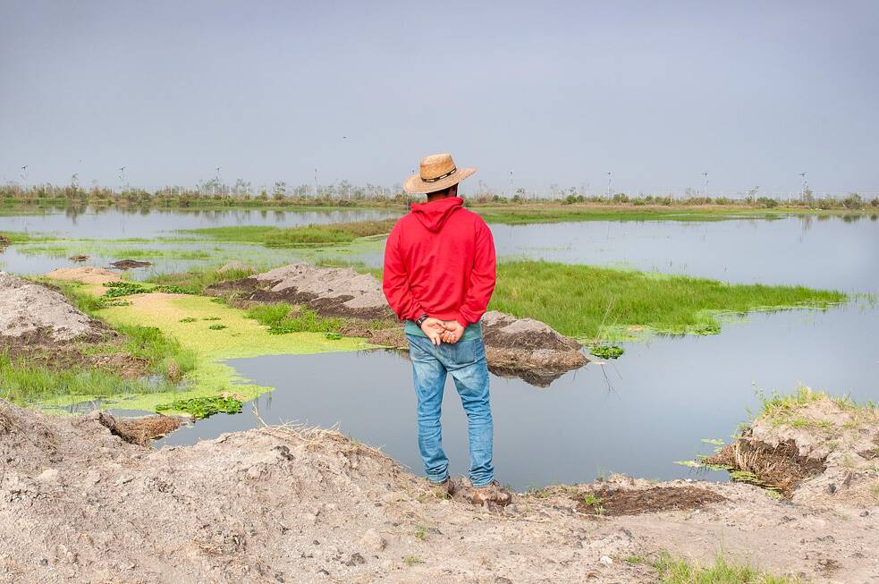 Daniel, um integrante da FPDT, contempla a paisagem de água e terra próxima ao leito do rio Papalotla.