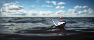 A paper boot in the water. © © Adobe Stock Paper boat