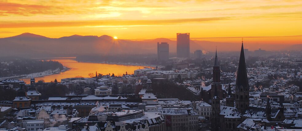 Sonnenaufgang über dem verschneiten Stadtzentrum von Bonn.