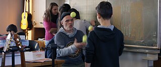 Ein jonglierender Mann in einem Klassenzimmer