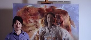 Die Malerin Sarah Schumann posiert vor dem lebensgroßen Collage-Gemälde einer Frau vor einem feurigen Hintergrund.