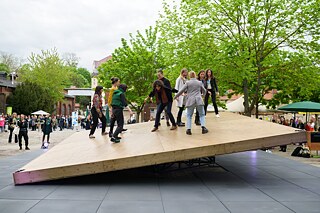 People balancing on a platform.