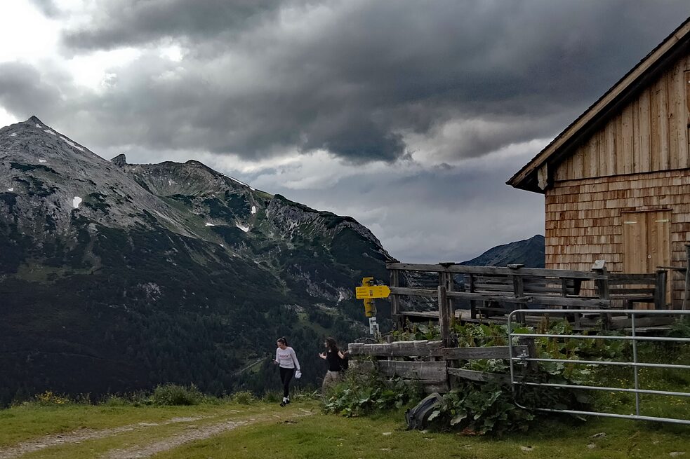 Eine Hütte rechts im Bild, die Alpen im Hintergrund.