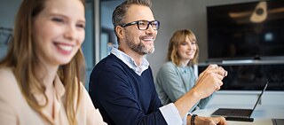 Gruppensituation mit 3 Personen am Tisch sitzend