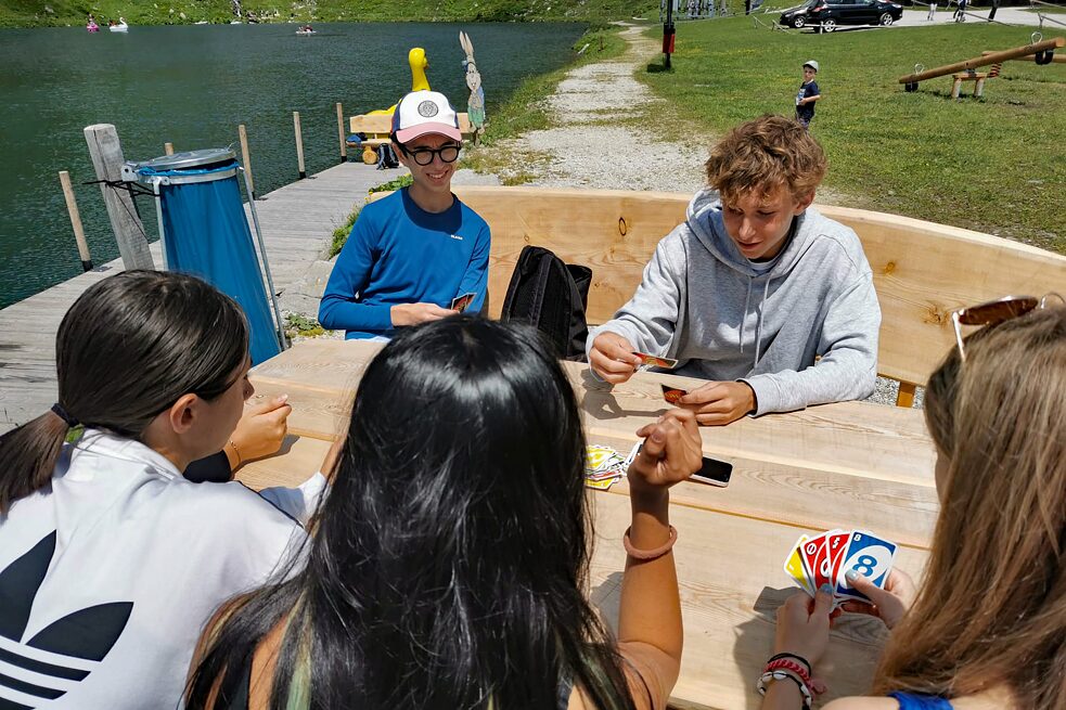 Jugendliche spielen Karten auf einem Rastplatz.