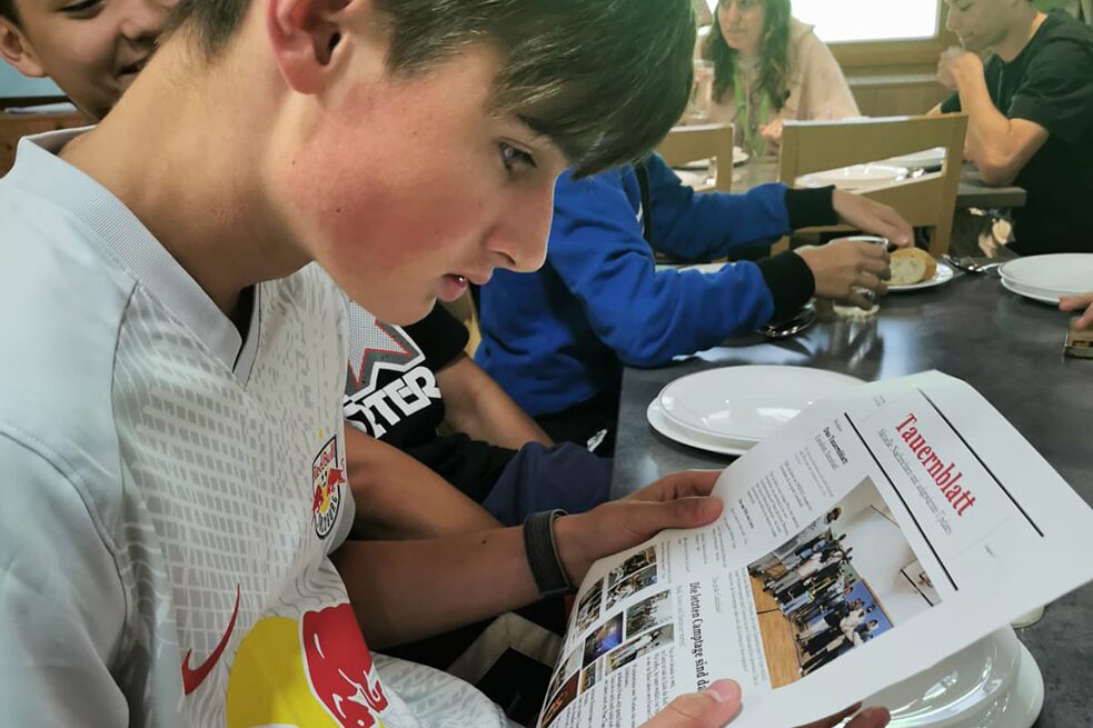 Jugendlicher beim Lesen des Tauernblattes.