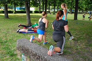 Eine Gruppe Frauen die im Park Fitness machen