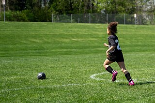 Ein Kind rennt einem Fußball hinterher