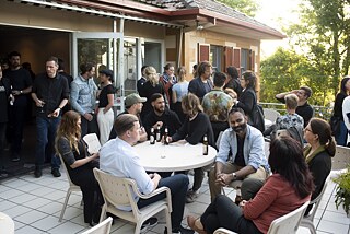 Guests sit at table, talk and drink