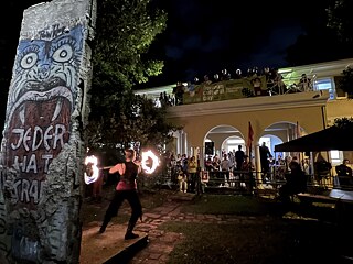 Fire Dancer performs in front of the Goethe-Institut Sydney and spectators watch her perform