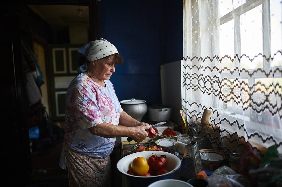 Власниця згорілої хати Тамара Леонідівна готує обід для волонтерів, які відбудовують її хату, яка згоріла рік тому під час російського наступу.
