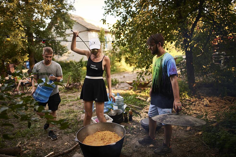 Частина волонтерів залишається у наметовому таборі, щоб приготувати вечерю решті будівельників.