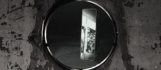 Illustration showing a surreal mirror on the street in the dark, reflecting the flowers in the window.