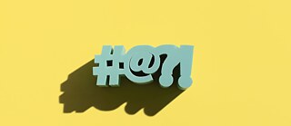 #@?! in 3D on a yellow background