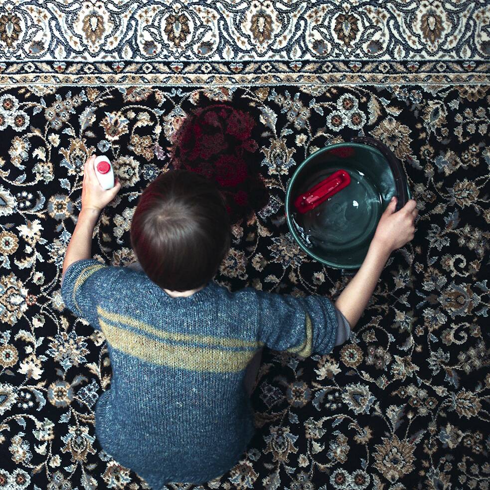 Jonathan (Sammy Schrein) nettoie une flaque de sang sur le tapis. Image fixe de la série Netflix Allemagne « Chere petite »