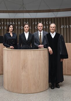 Filmstill aus „Ökozid”: drei Anwälte und ein Richter am Internationalen Gerichtshof