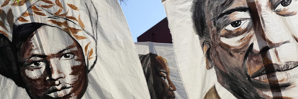 Racism – Three portraits of Black Brazilian historical personalities are depicted on banners