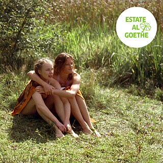 Fermo immagine tratta dal film “Mitte Ende August”: due ragazze siedono su un prato