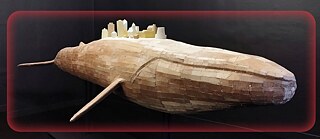 Illustration is showing a wooden whale carrying models of the houses on its back, this work of art is hanging in a dark space. 