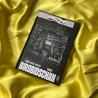 Tomer Dotan-Dreyfus Buch "Birobidschan" liegt auf einer goldglänzenden Decke, die Falten wirft. © © Goethe-Institut Dänemark/ Nanke Nicolaisen Tomer Dotan-Dreyfus: Birobidschan (Voland & Quist, 2023)