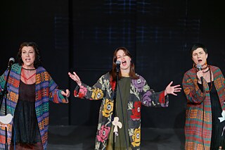 The three singers of the folk ensemble Kriwi sing on stage