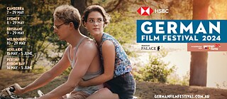 Banner German Film Festival 2024 - Still from Andreas Dresens film From Hilde, with Love; a young man and woman on a motorbike