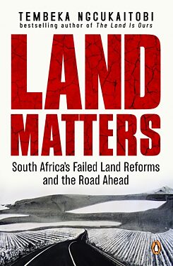 The title of the book Land Matters is written in large red letters, with a landscape of lakes, fields and hills below in high-contrast black and white