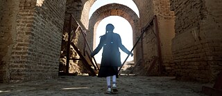 Ein Mädchen steht im Gegenlicht in einem archäologischen Gebäude