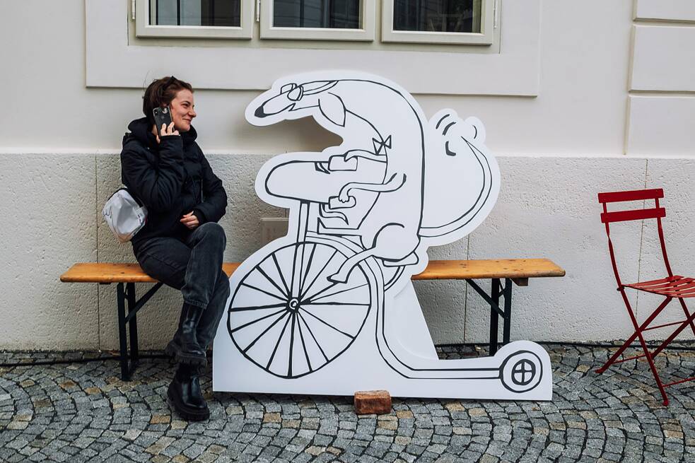 Woman sitting with an illustration on the street