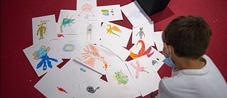 At the end of the workshop, we collected the children’s art works. And the child is looking for his own art in the mix.